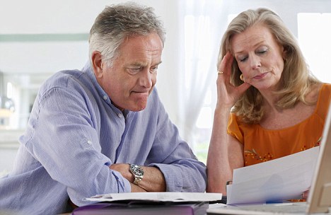 Senior couple looking at bills, sitting at dining table. Image shot 2009. Exact date unknown.